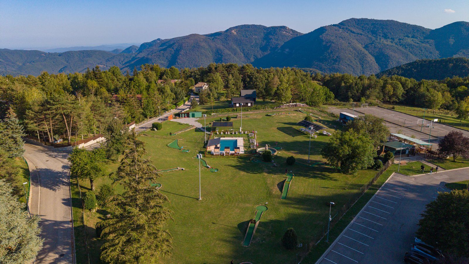 Vista aèria del recinte d’Els Ocells, amb el minigolf, la piscina i les muntanyes de la Vall de Camprodon
